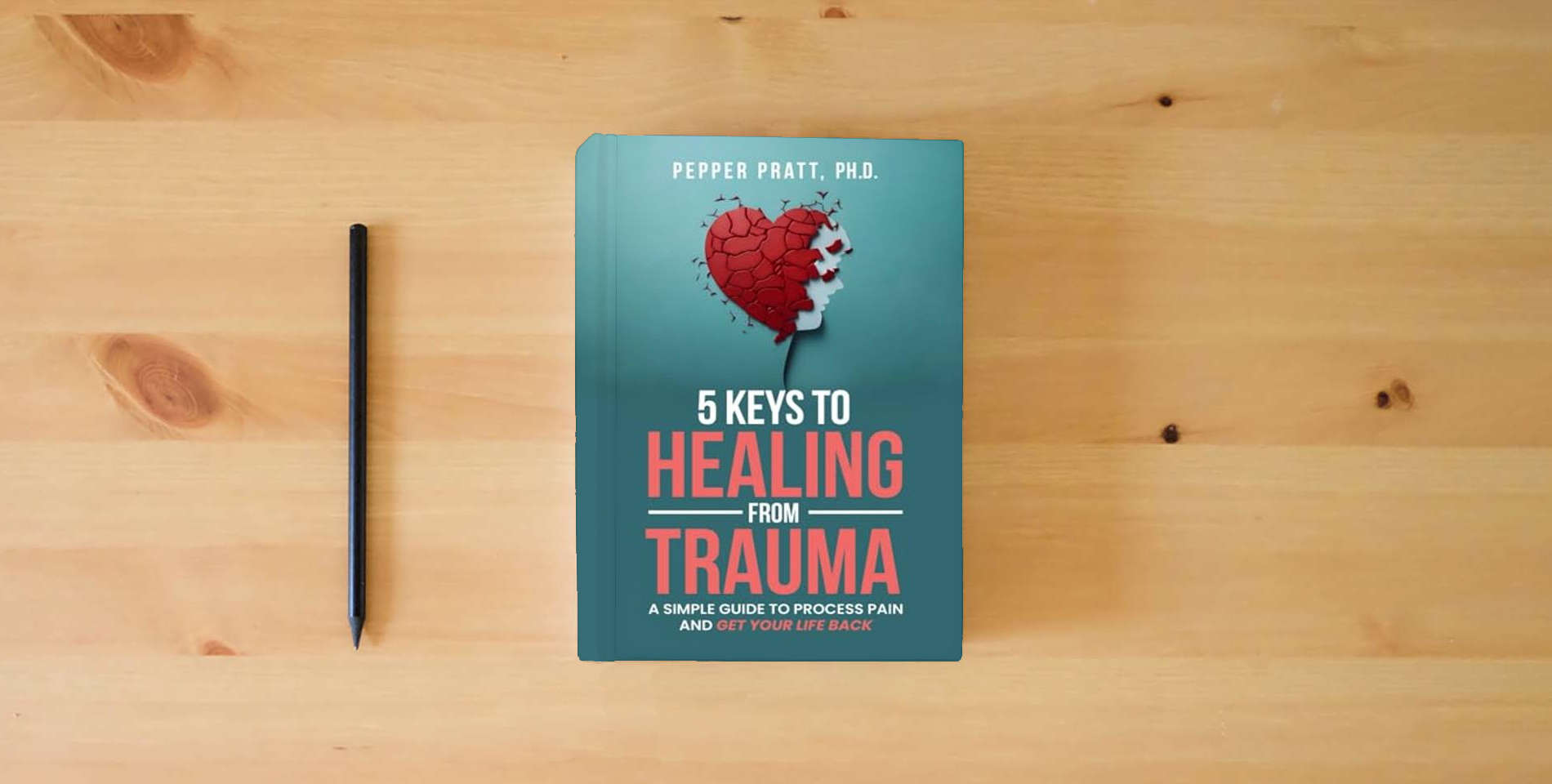 The book 5 Keys to Healing From Trauma: a simple guide to process pain and get your life back is on the table
