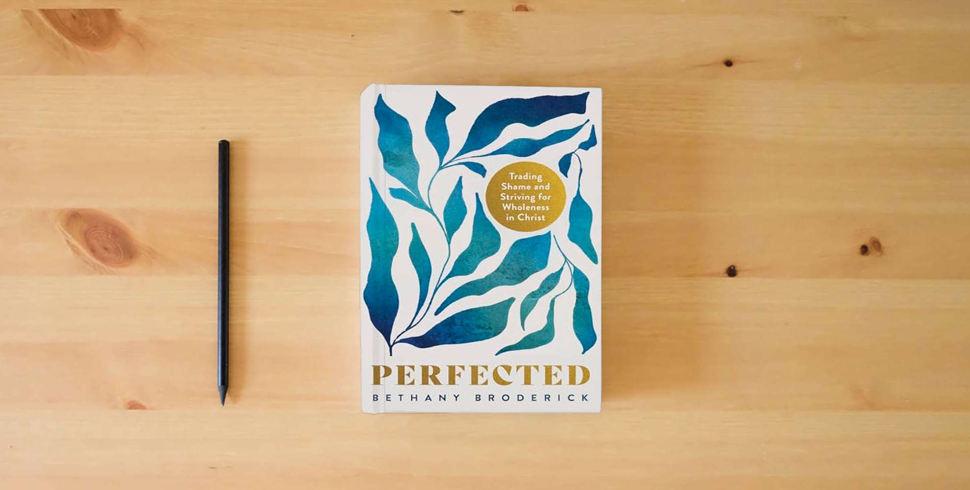 The book Perfected: Trading Shame and Striving for Wholeness in Christ is on the table