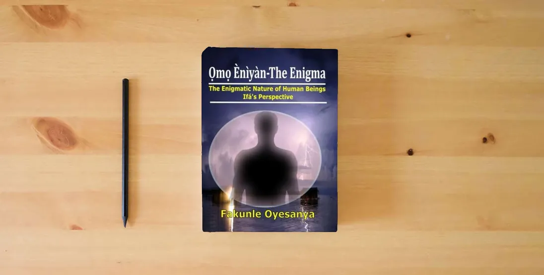 The book Omo Eniyan-The Enigma: The Enigmatic Nature of Human Beings (Ifa' Perspective)} is on the table