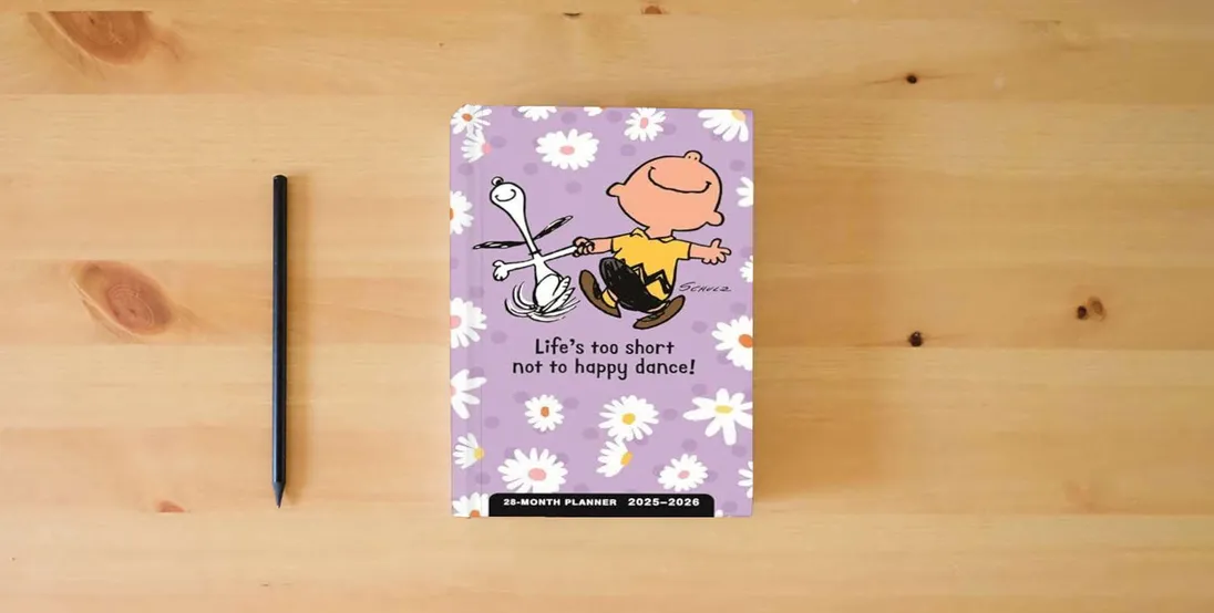 The book Peanuts Happy Dance: 2025-2026 28-Month Inspirational Pocket Planner} is on the table