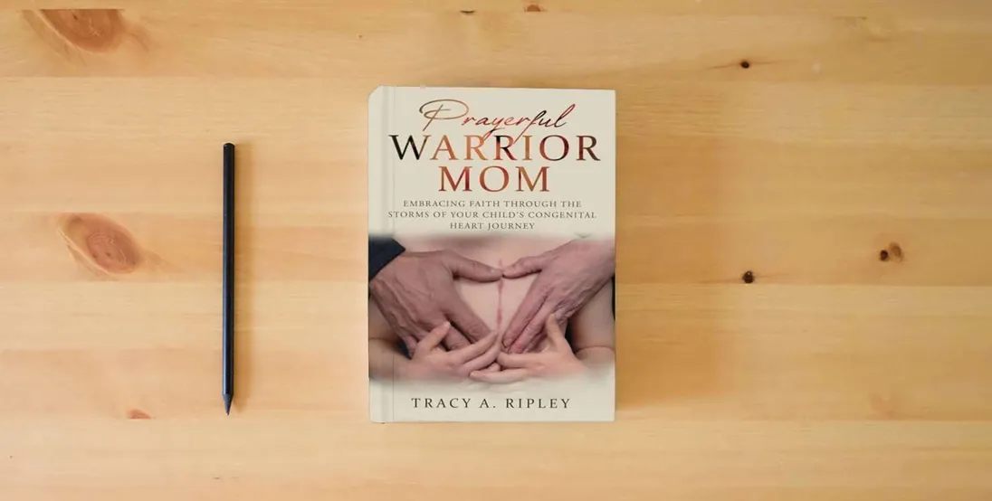 The book Prayerful Warrior Mom: Embracing Faith through the Storms of Your Child's Congenital Heart Journey} is on the table