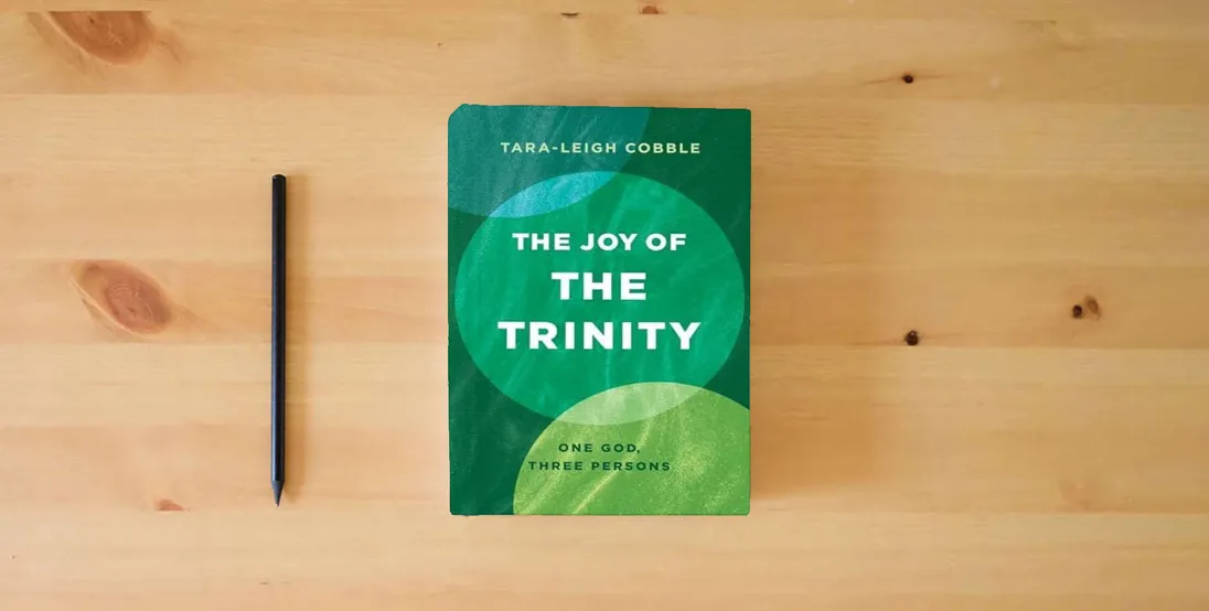 The book The Joy of the Trinity: One God, Three Persons} is on the table