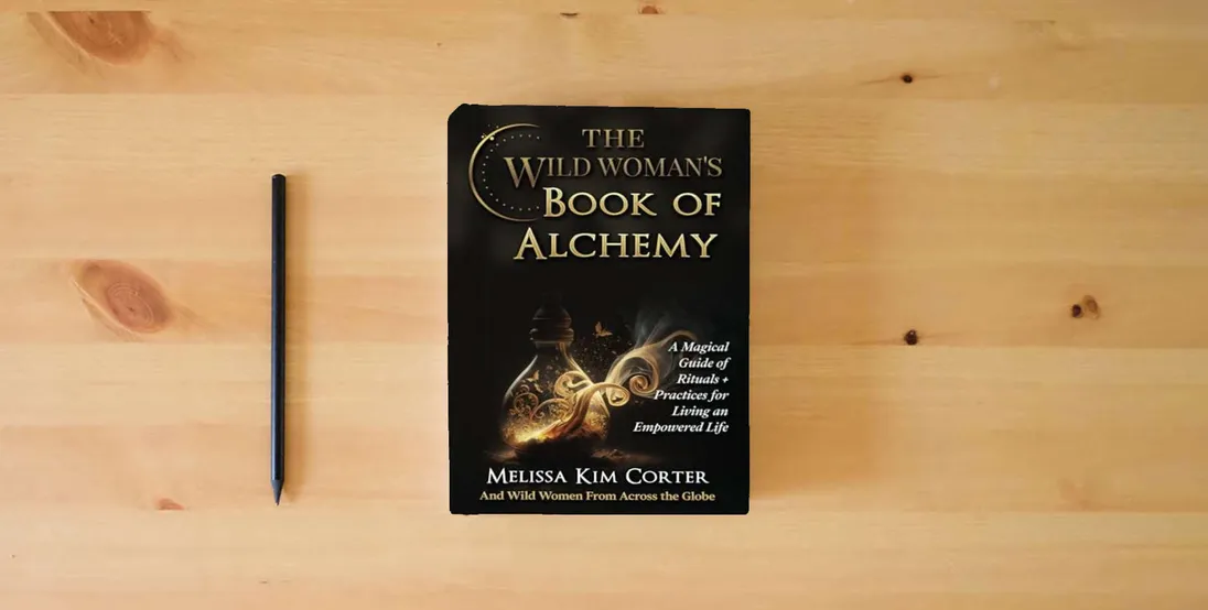 The book The Wild Woman's Book of Alchemy: A Magical Guide of Rituals + Practices for Living an Empowered Life} is on the table